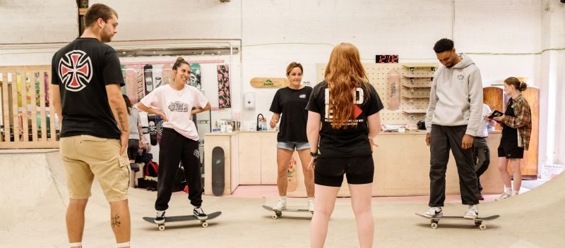 A group of skaters standing on boards in a coaching session